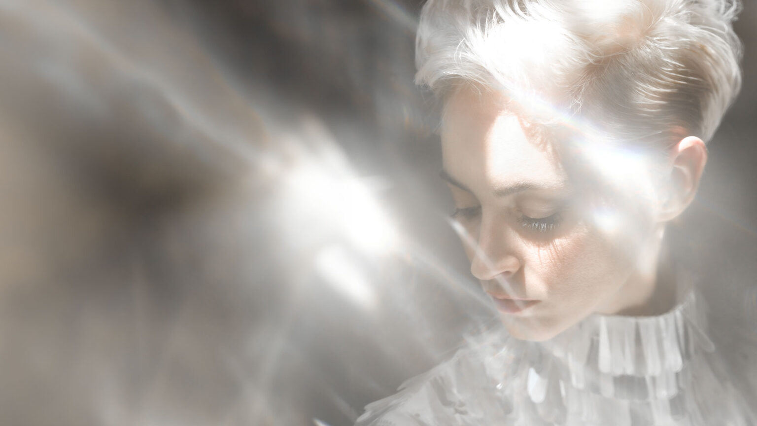Woman with platinum blonde hair in soft ethereal light for Blonde Elevation brand concept.