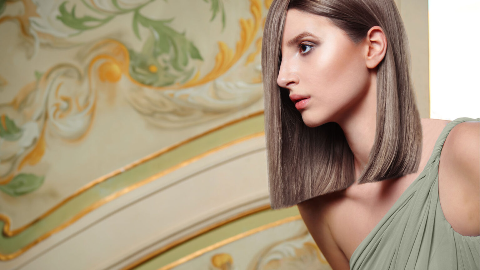 Portrait of a woman with sleek straight hair in an asymmetrical bob, wearing a light green dress, with an ornate decorative background.