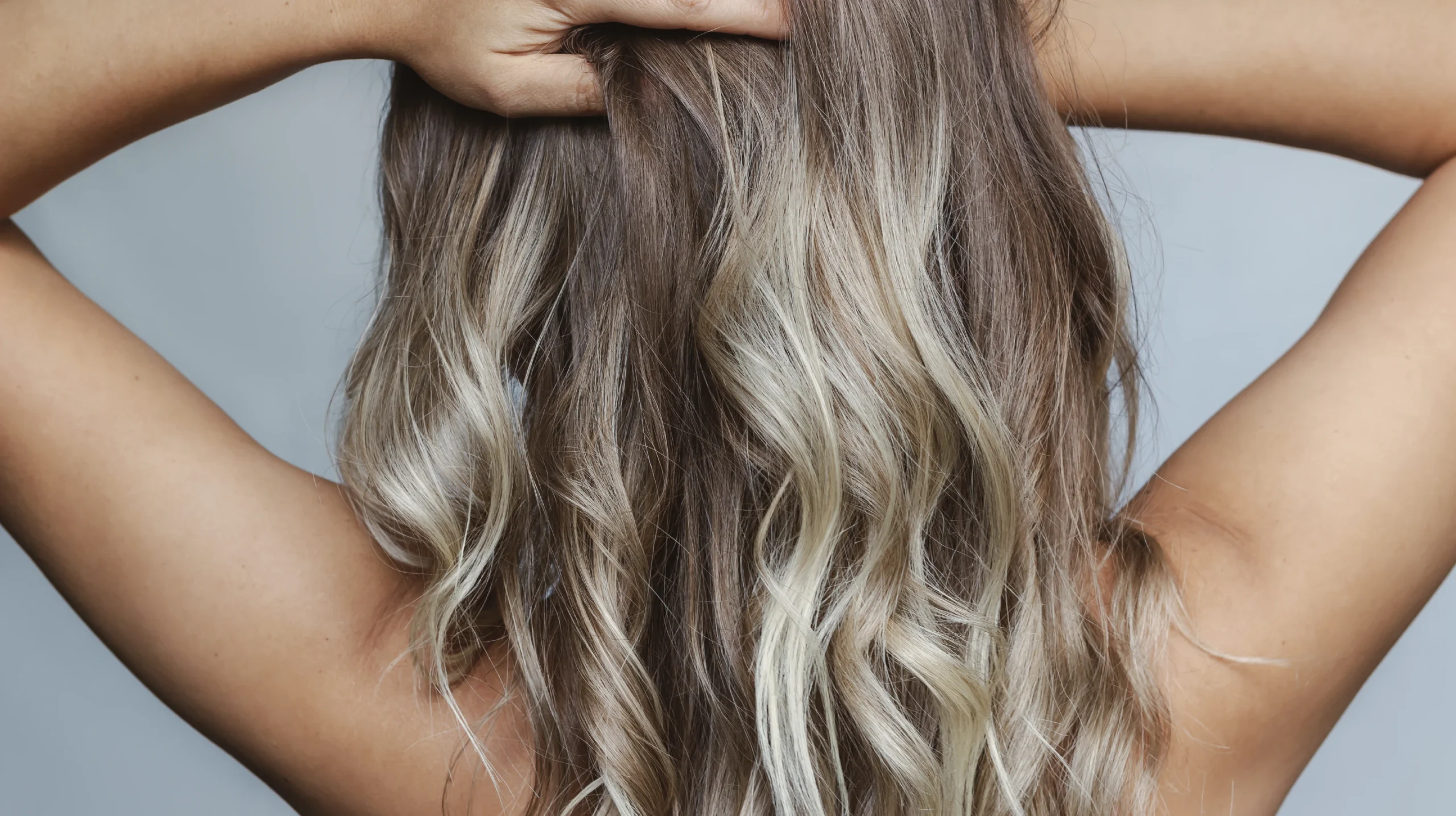 Back view of long wavy hair with soft air-touch highlights and natural color blending