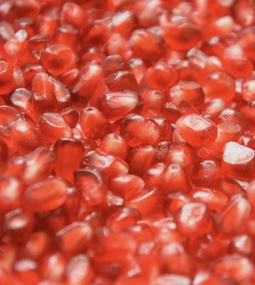 Close-up of red pomegranate seeds tightly packed together with glossy translucent surfaces.